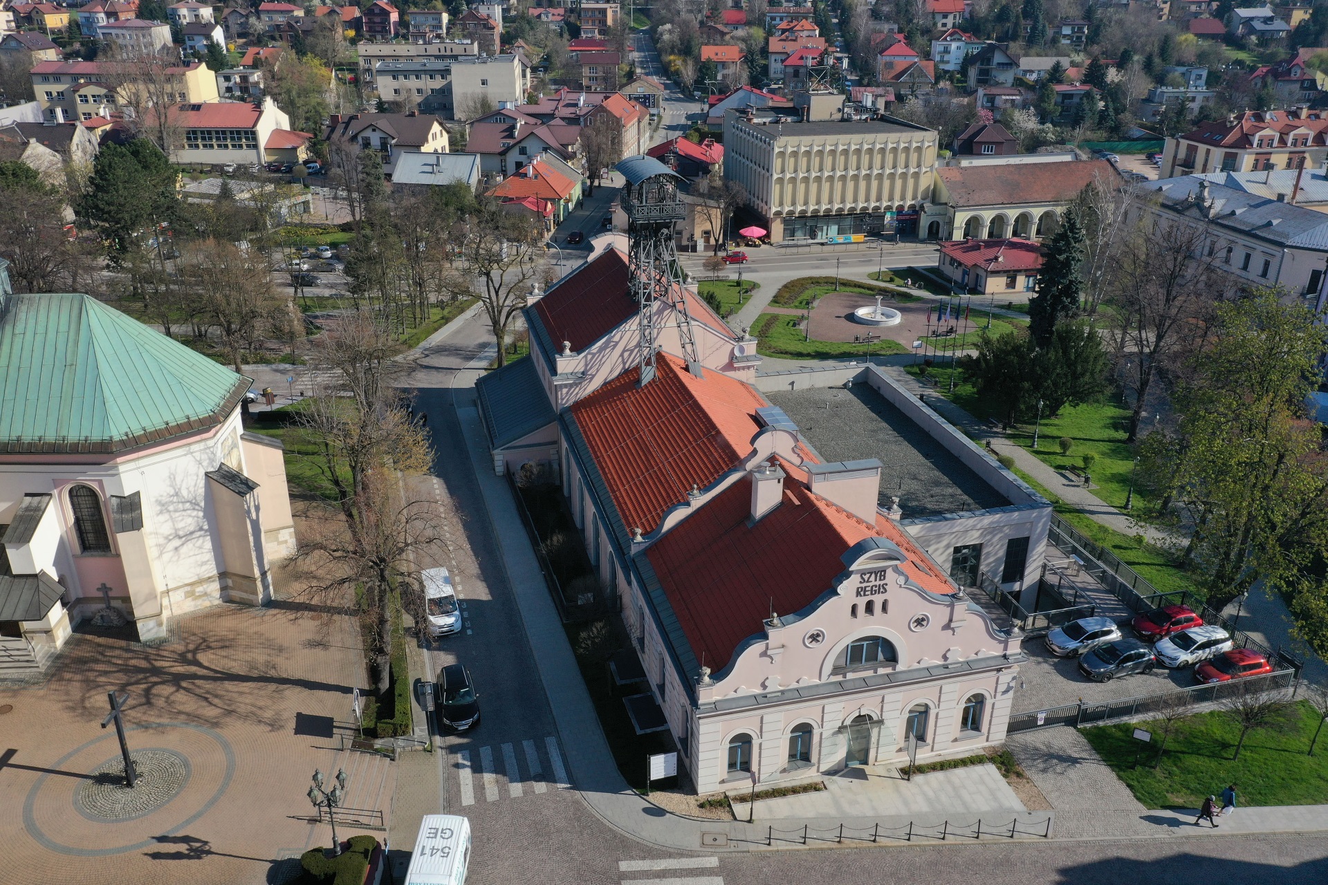 Widok z lotu ptaka na szyb Regis. Otynkowany na jasny kolor podłużny budynek z wieżą szybową