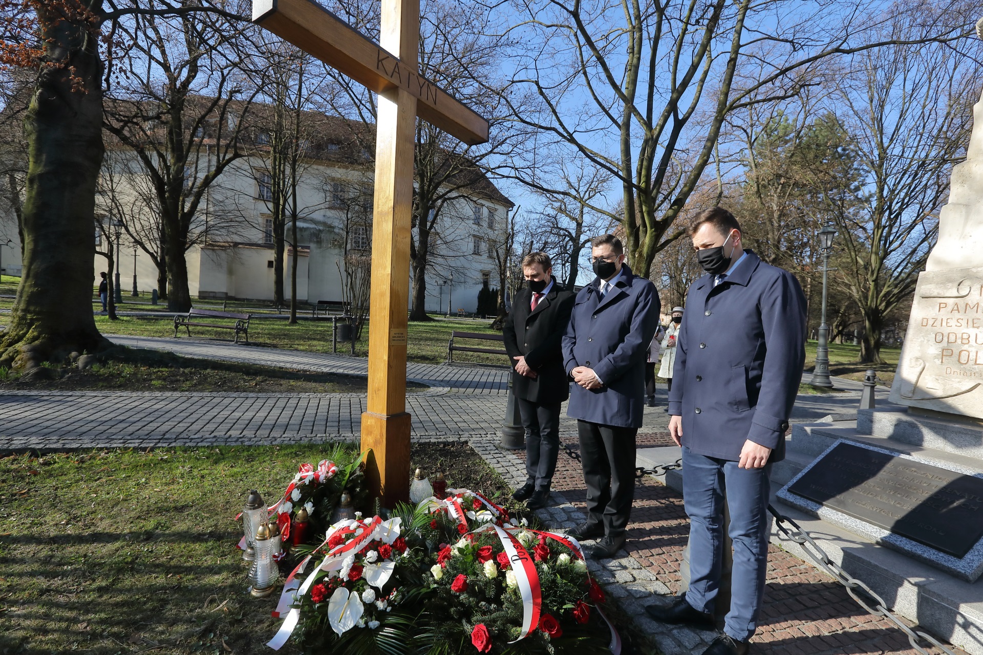 Przed krzyżem z napisem KATYŃ stoją przedstawiciele Kopalni Soli "Wieliczka": prezesi Paweł Nowak i Michał Roehlich oraz dyrektor Tomasz Broniowski