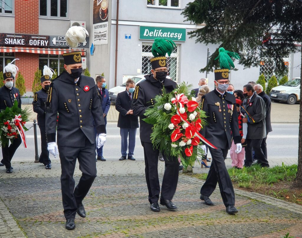 Przedstawiciele Kopalni Soli "Wieliczka" S.A. składają kwiaty w dniu 3 maja. W galowych mundurach prezes Paweł Nowak (w środku), dyrektorzy Tomasz Broniowski (po lewej) i Damian Konieczny (po prawej)