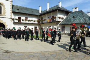 Wieliccy górnicy wchodzą na dziedziniec starosądeckiego klasztoru. W tle brama oraz jednopiętrowe budynki z balkonem