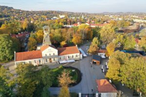 Widok z lotu ptaka. Jesienny park w słoneczny dzień, budynek szybu Daniłowicza z wieżą szybową po środku