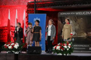 Pięć dziewczynek na scenie w komorze Warszawa podczas patriotycznego koncertu