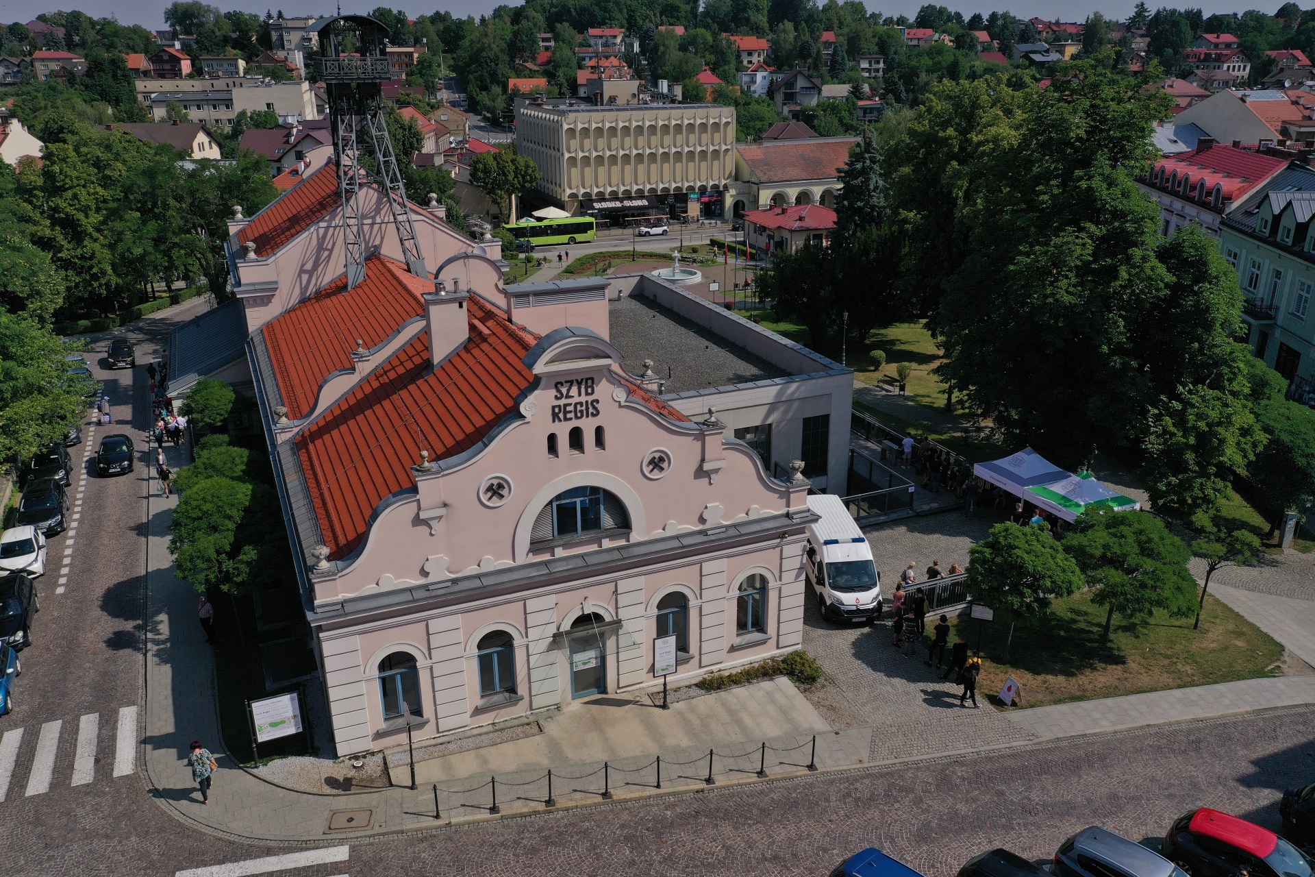 Widok na szyb Regis z lotu ptaka. Niski różowy budynek z wieżą szybową, kryty czerwoną dachówką