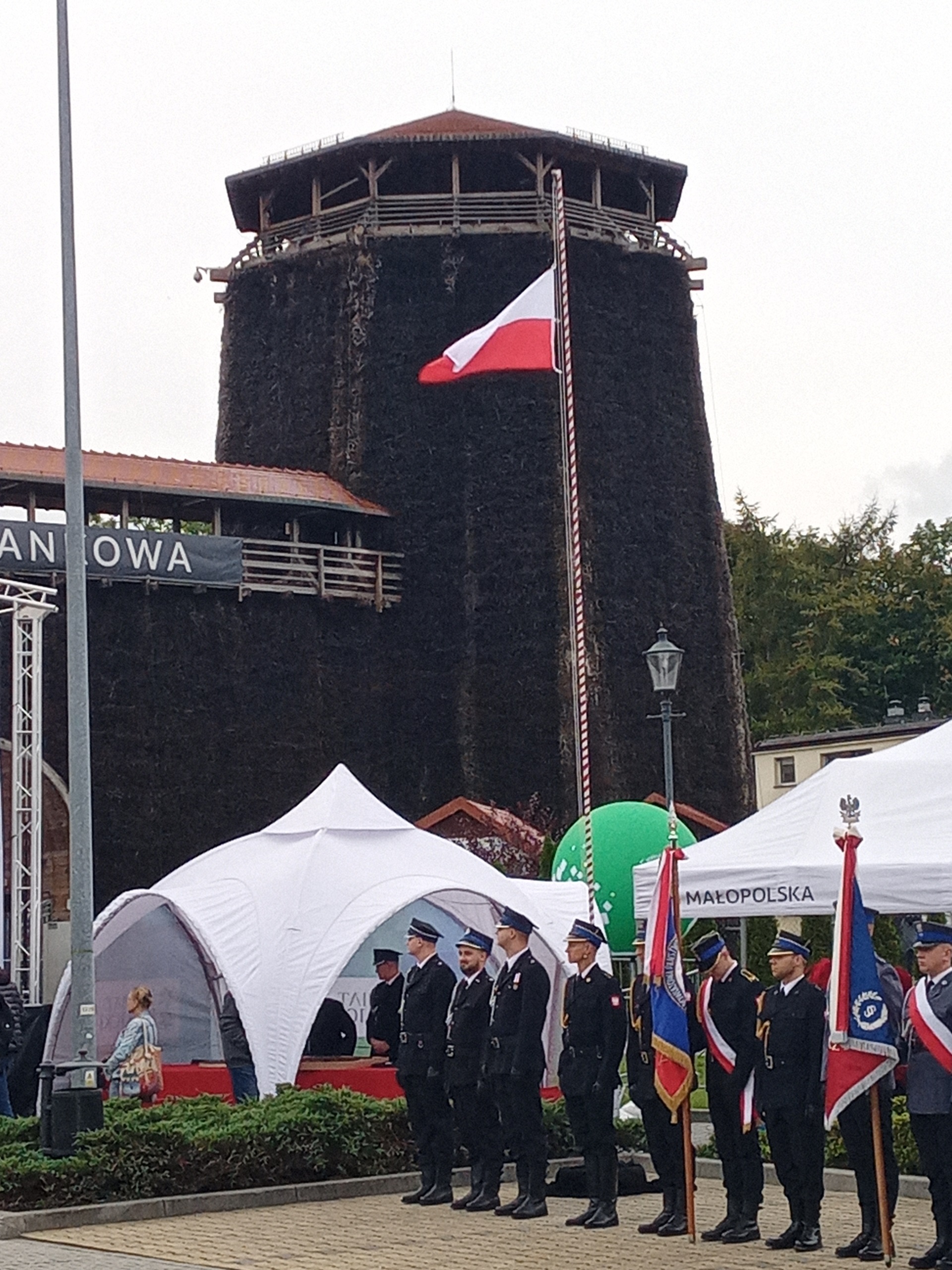 Flaga RP powiewająca na tle wieży tężni solankowej