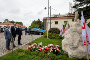 Delegacja kopalni składa kwiaty. U stóp pomnika biało-czerwone wiązanki