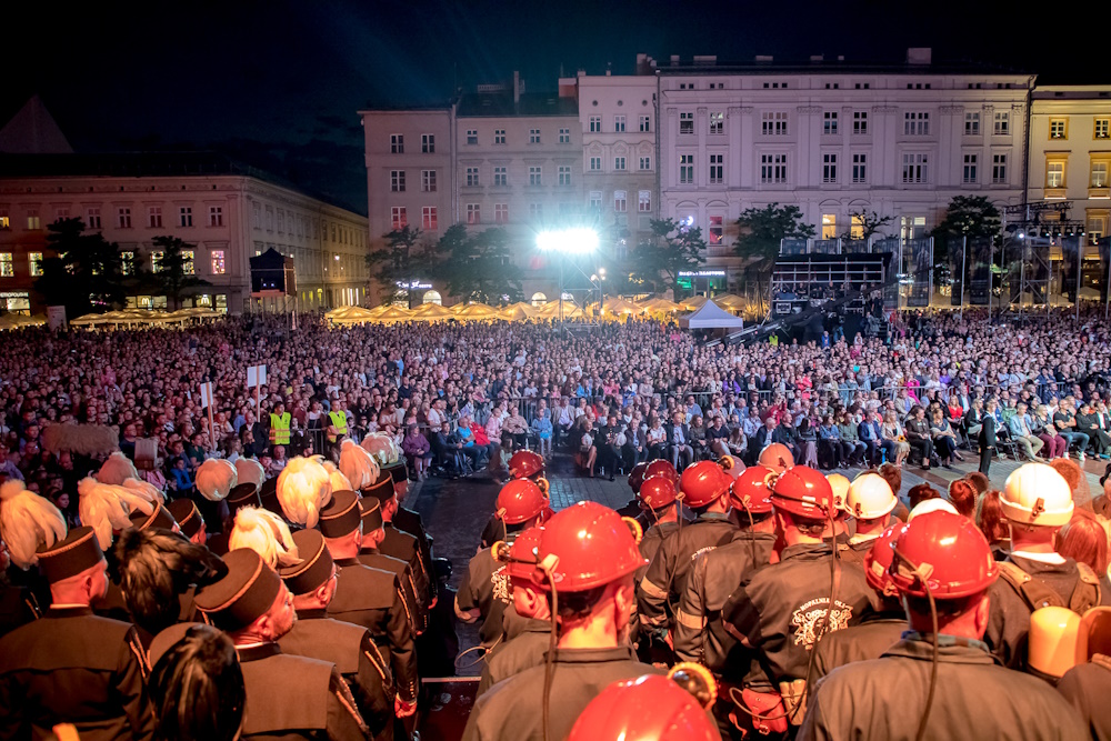 Widok na wypełnioną widzami płytę rynku - ujęcie zza pleców stojących na scenie górników