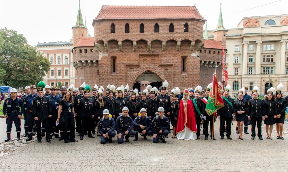 Grupowe zdjęcie górników na tle Barbakanu