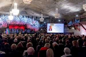 Widok na komorę Warszawa. W głębi scena oraz telebim z wyświetlaną prezentacją
