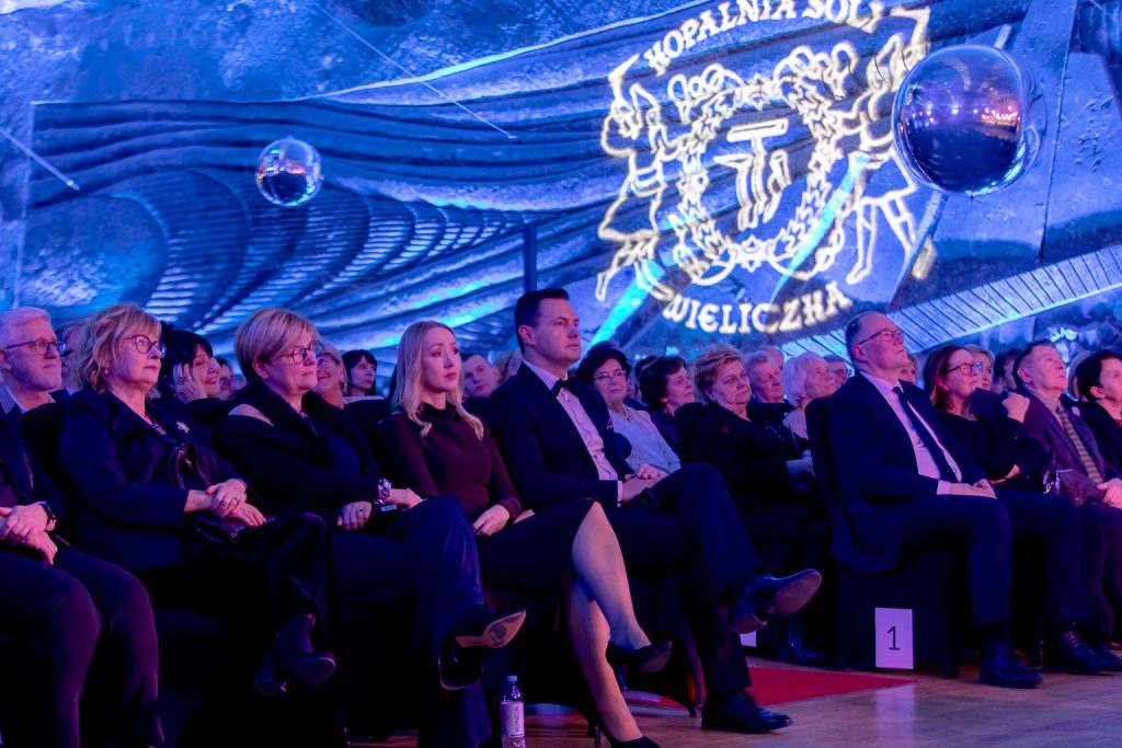 Publiczność. W tle białe świetliste logo kopalni wyświetlone na solnej ścianie