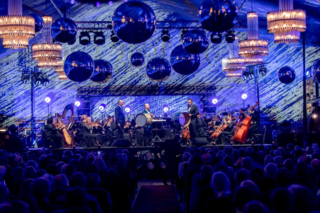 Widok na scenę. Przygaszone żyrandole. Niebieska iluminacja