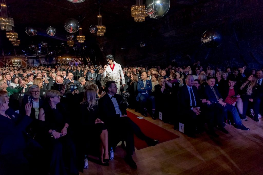 Elvis przechadza się między publicznością. Stąpa po czerwonym dywanie