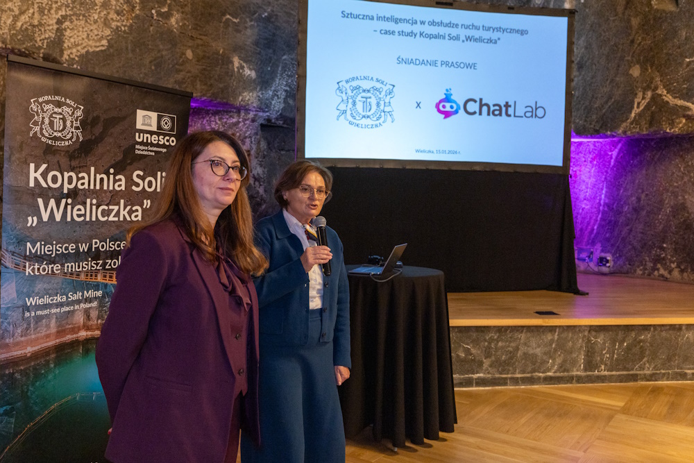 Prezes Barbara Zięba-Godula i rzecznik prasowy Agnieszka Wolańska otwierają spotkanie. W tle ekran z prezentacją. Panie stoją po lewej stronie kadru