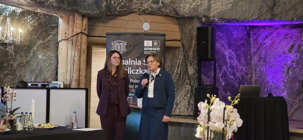 Barbara Zięba-Godula i Agnieszka Wolańska otwierają spotkanie. Za ich plecami roll-up ze zdjęciem kopalni