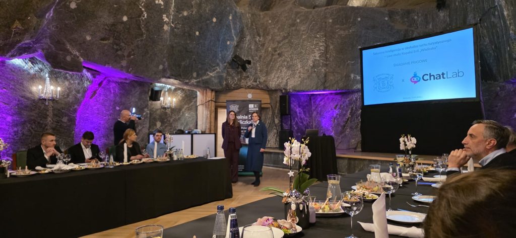 Śniadanie prasowe. Widok na komorę Haluszki, uczestników oraz nakryte stoły z poczęstunkiem