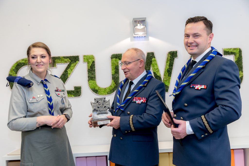 Prezes Leśny wręcza solny harcerski krzyż. Prezes Sadkiewicz adres gratulacyjny