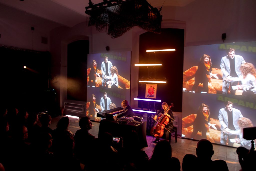 Występ muzyczny, w tle na czterech ekranach projekcja filmu