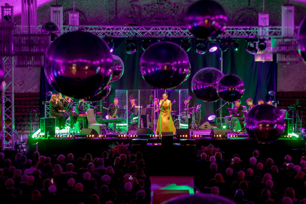 Artystka w długiej żółtej sukni na scenie