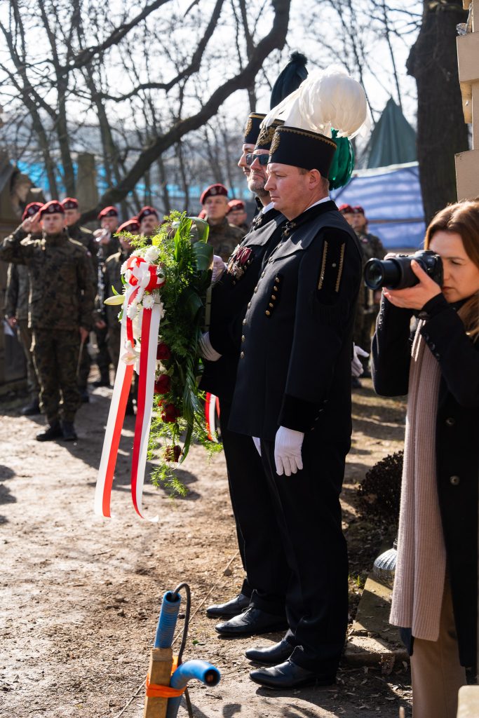 Górnicy w galowych mundurach na cmentarzu w Podgórzu. Słoneczny dzień, przedwiośnie