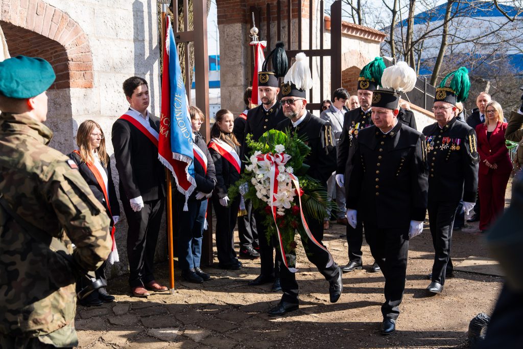 Górnicza delegacja zmierza z wieńcem kwiatu do grobu Dembowskiego i powstańców krakowskich