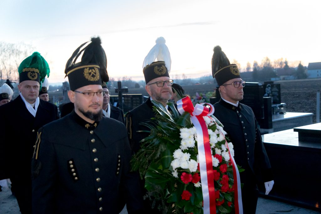 Górnicy w galowych mundurach z biało-czerwonym wieńcem