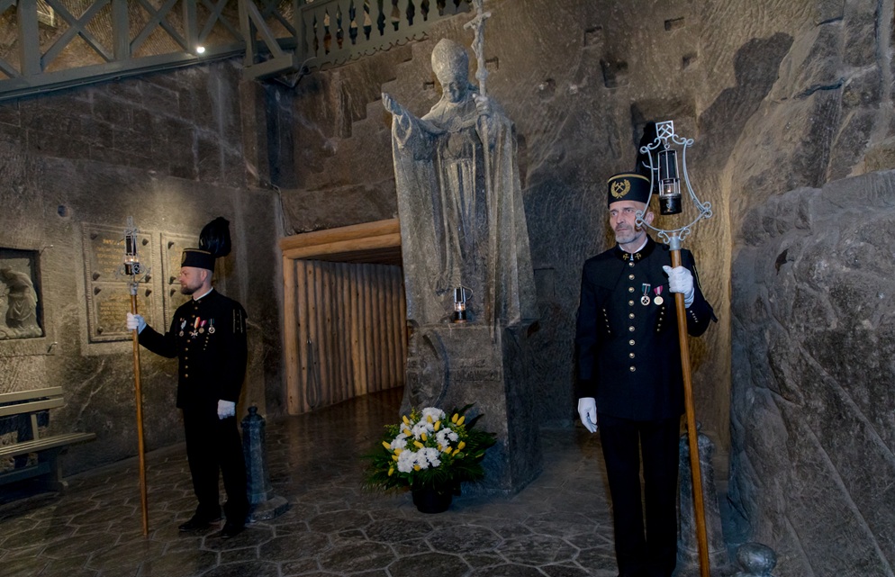 Pomnik Jana Pawła II, po bokach stoją górnicy z lampkami zicherkami