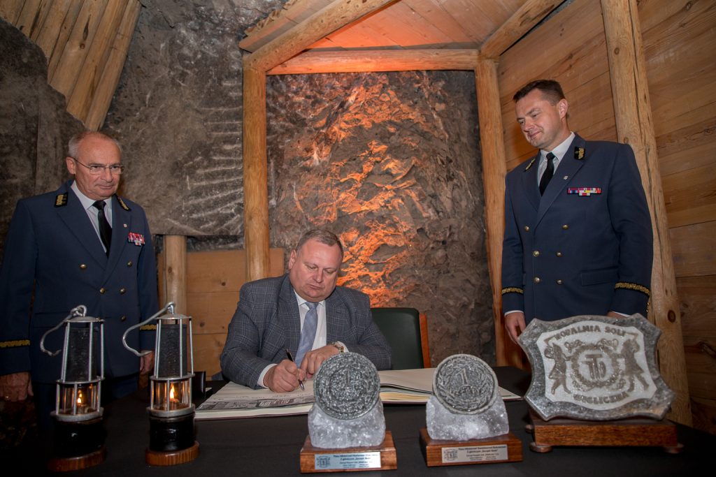 Wpis do księgi zwiedzających. Asystują prezesi wielickiej kopalni