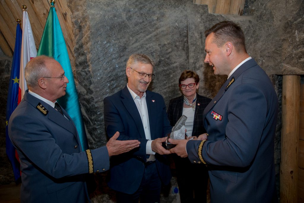 Prezesi kopalni wręczają członkom komisji pamiątkowe solne rzeźby